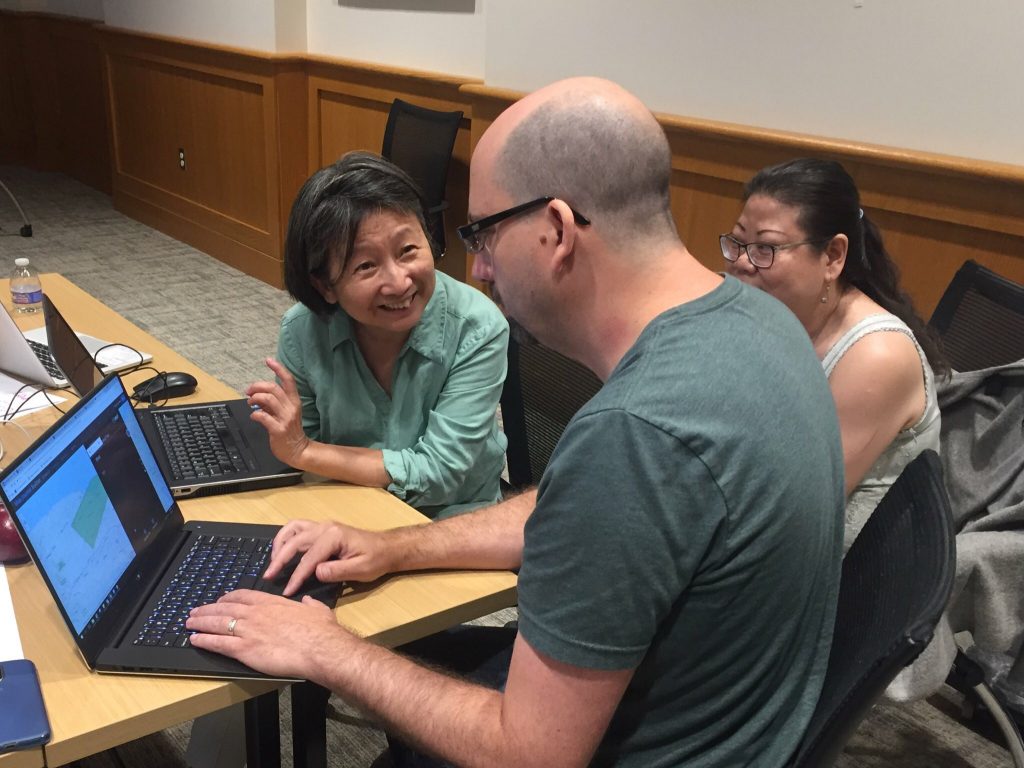Image of faculty working with two library staff on a mapping project.